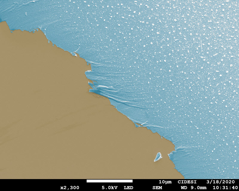 SUBJECT: 150 nm of Bi deposited on Si by RF Sputtering at RT. Ocean edge effect due to release of adhesive tape used during the Bi deposit to create a step. Sand color corresponds to Si and watercolor correspond to Bi, the sample was tilted to improve the like-ocean view; CREDIT: Jesus Javier Alcantar Peña, Julian Carrillo (coloring),Edgar Sierra (deposition of Bi material), CIDESI – Queretaro; METHOD/INSTRUMENT: JSM-7200F FESEM